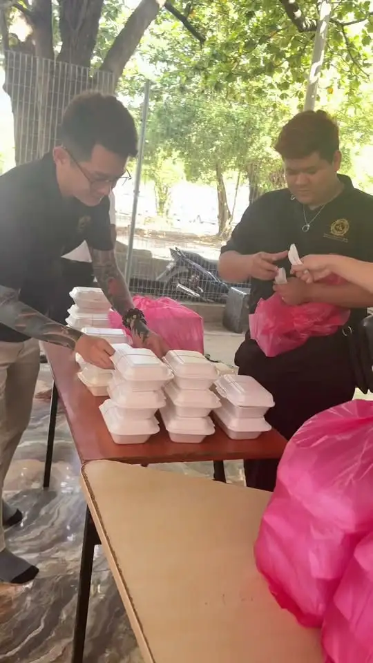 义工在派饭点把一盒盒热饭装进袋子